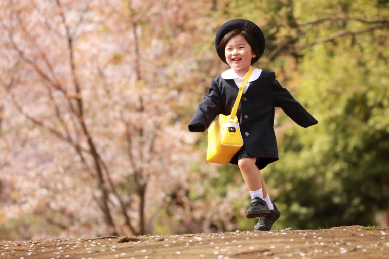桜の中を走る幼稚園生