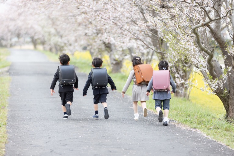 桜の中を走る小学生